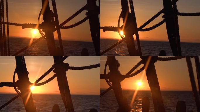 日落穿过一艘旧帆船的护罩和索具。海景慢动作视频