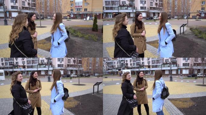 少女友谊。三个年轻漂亮的女孩在街上聊天。他们很高兴。女孩很高兴见到。从斯特迪卡姆拍摄。慢动作。