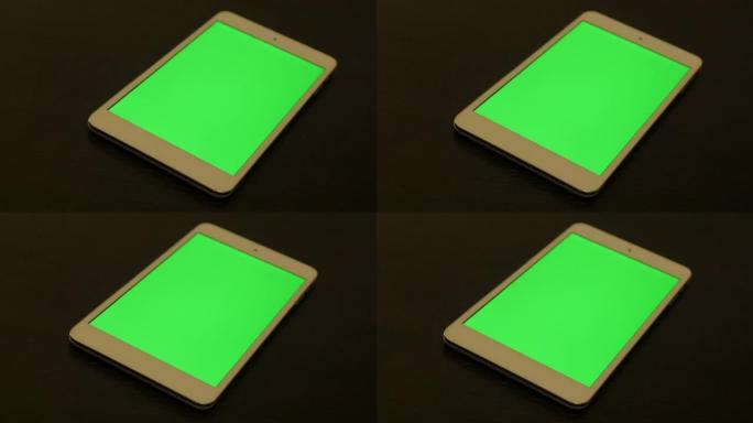 木质桌子4K上绿屏显示的银色电脑平板电脑