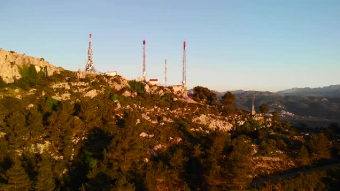西班牙阿利坎特滨海阿尔塔塞加里亚山日落时电信天线的空中无人机视图