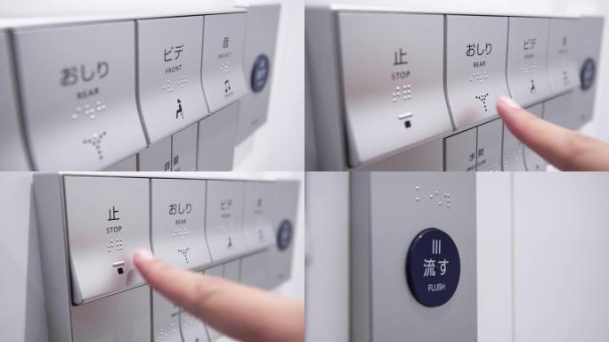 女人手指按压日本自动洁厕机按钮。