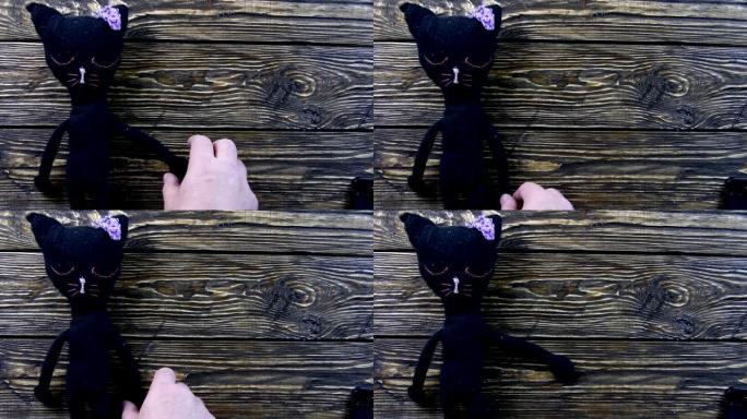 木制背景上的玩具毛绒黑猫