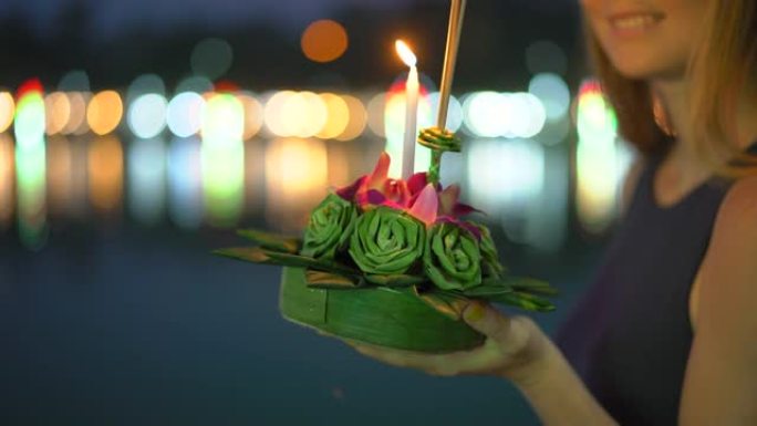 慢镜头拍摄了一个美丽的年轻女子，她手里拿着一支蜡烛，庆祝泰国的一个假日