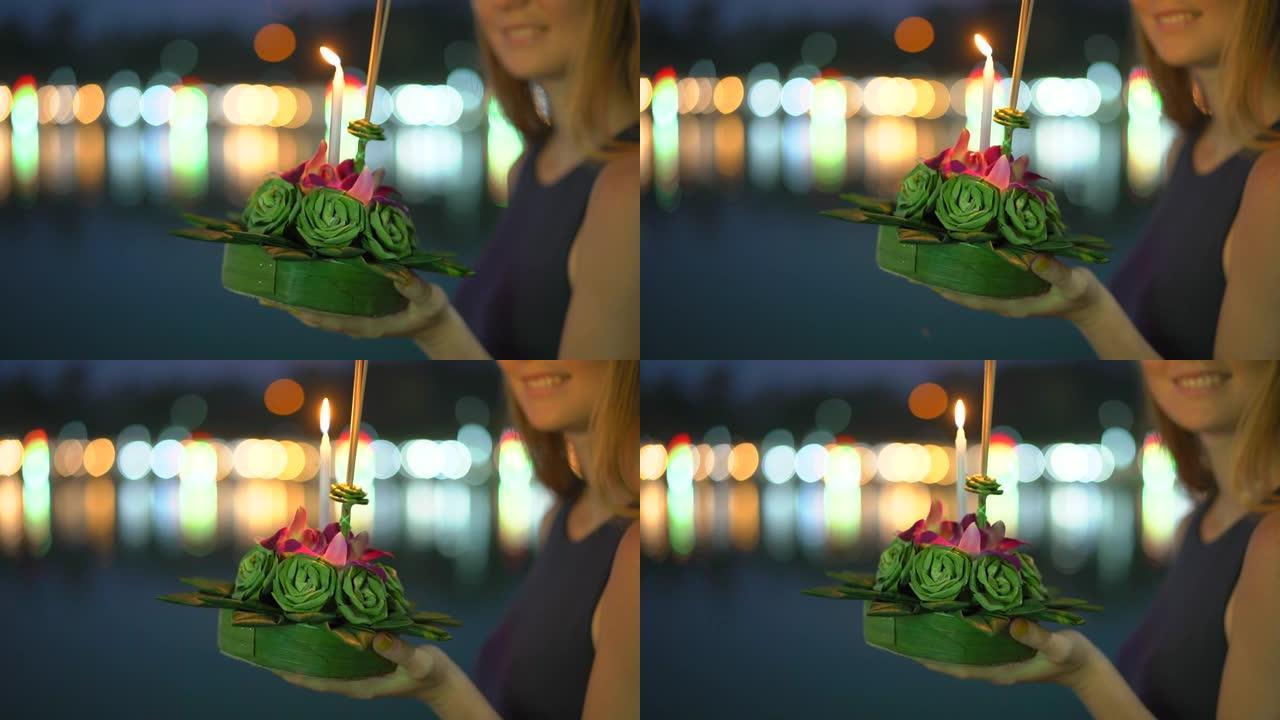 慢镜头拍摄了一个美丽的年轻女子，她手里拿着一支蜡烛，庆祝泰国的一个假日