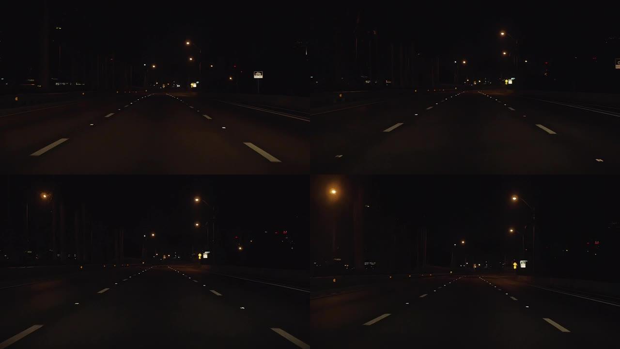 晚上迈阿密海滩的柏油路。汽车前部的观点。白线，黑暗的天空，闪光的路灯，慢动作4K。