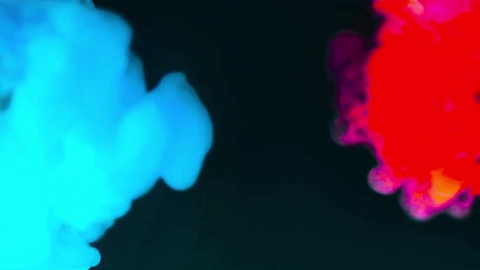 抽象背景，红色和蓝色滴模糊烟雾。抽象的形状孤立在黑暗的背景上。慢动作液体以阿尔法高清4k分辨率移动。