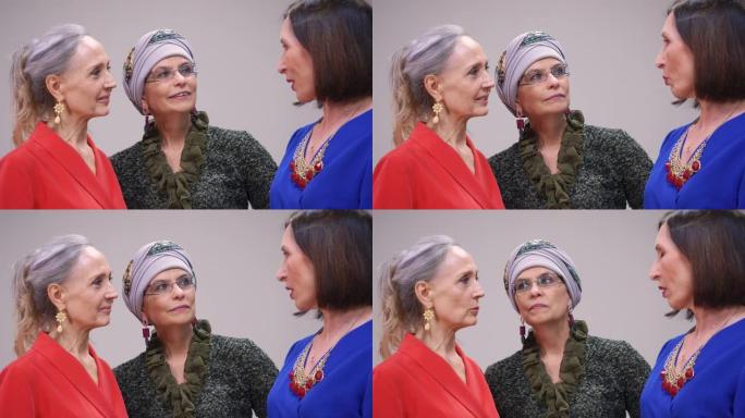 三个成年女人在友好见面时谈论一些事情。幸福女人的朋友在会上闲聊。女性友谊概念。