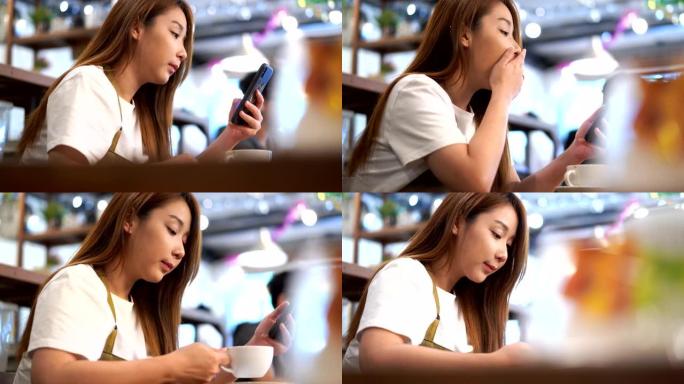 周末，一名亚洲妇女使用手机填充困倦并在咖啡厅喝咖啡的特写镜头