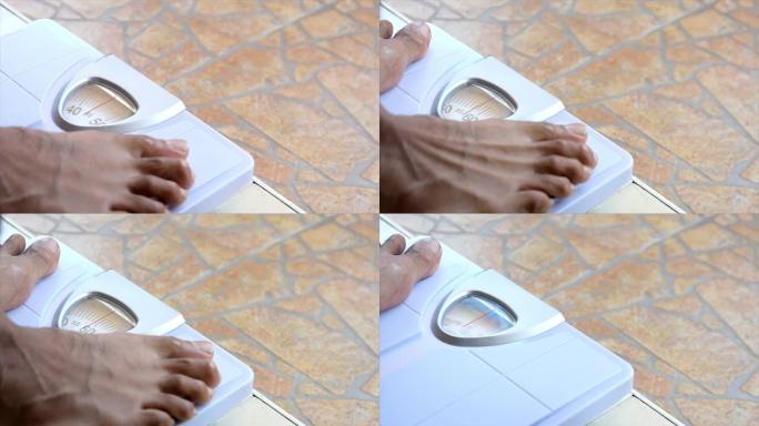近距离站立在体重秤上的人的脚，以测量体重减轻。体重秤达到健康减肥的概念。