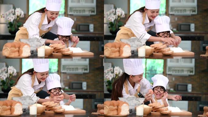 美丽的亚洲女人和可爱的戴眼镜的小男孩准备一起在家厨房做饭。生活方式和家庭。自制食物和配料。两人裂破蛋