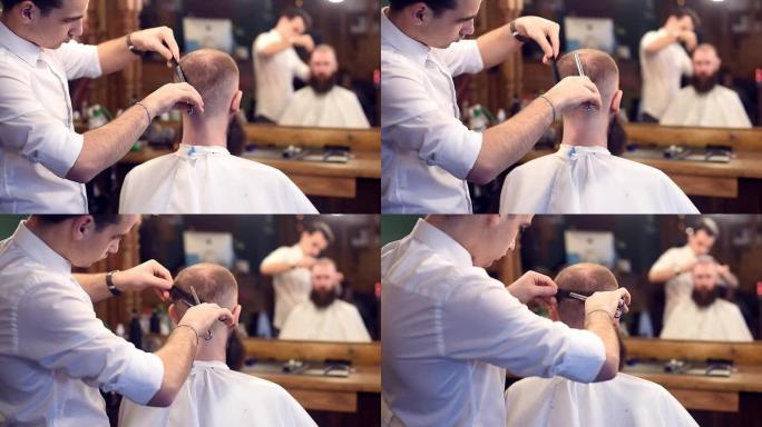 男人理发师在男性发廊用剪刀剪头发。裁剪的男性客户坐在后面。镜子中的模糊反射