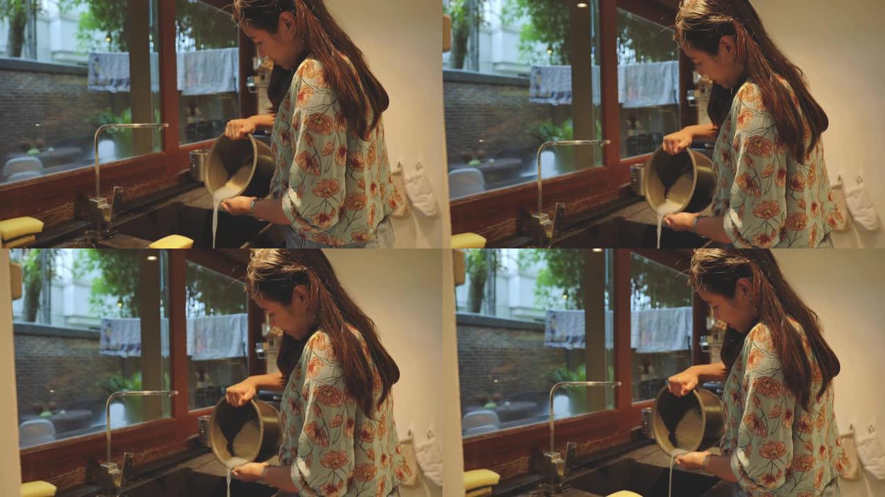 亚洲女子在家厨房煮饭的场景。