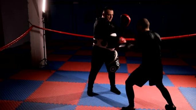 拳击手在健身房与教练进行个人练习