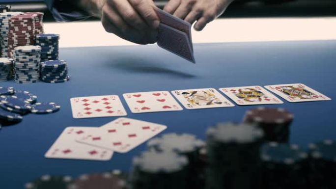 幸运的扑克玩家在桌子上露出他的牌