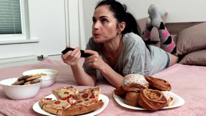 女人躺在床上，吃甜面包和一块披萨