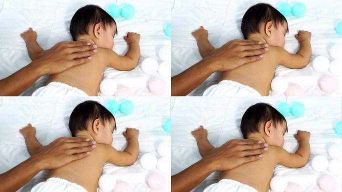 婴儿用手拍在床上睡觉