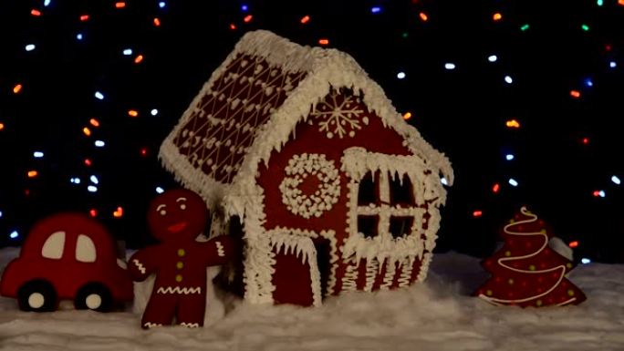 手工制作的可食用姜饼屋，小矮人，新年树，汽车，雪装饰，花环背景照明