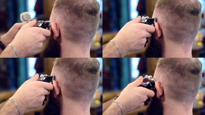 剪发机的特写镜头，用短发的手做男性发型。在耳朵附近剪头发，刷掉头发