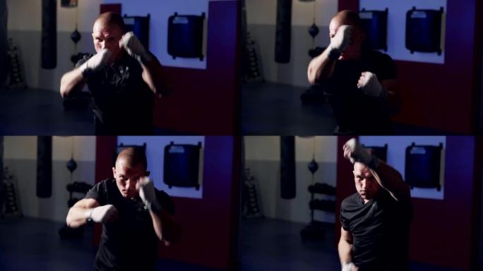 男子拳击手训练在健身房向相机挥拳，在慢动作中进行阴影搏斗。