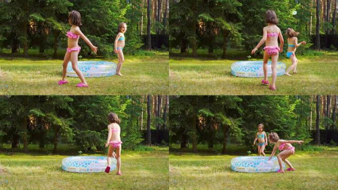 夏季，两个小女孩在游泳池旁玩水气球