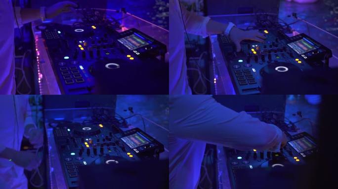 在夜总会的舞会上，DJ控制器和音乐控制台在五颜六色的灯光下。DJ调音台播放器和迪斯科派对的声音控制台