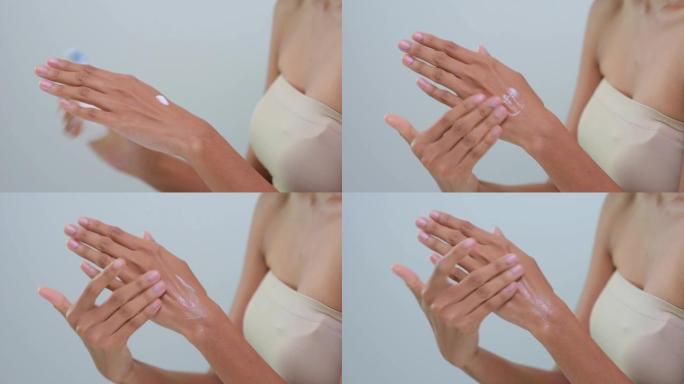 近手值女人使用皮肤发光的乳液制作面部表情