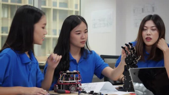 亚洲工程师团队在实验室组装和测试机器人反应。建筑师设计电路和工程师会议共享技术思想和协作开发机器人。