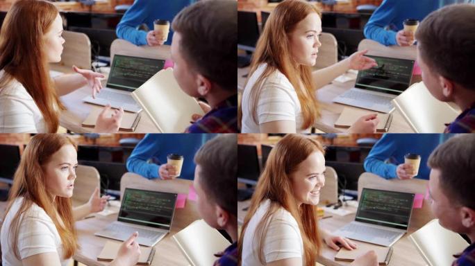 年轻的女性软件开发人员，红发向队友解释她的想法，并指向笔记本电脑屏幕上键入的代码，跟踪左中枪