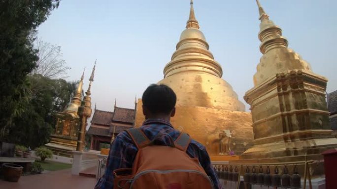 亚洲男子游客带着背包走进寺庙
