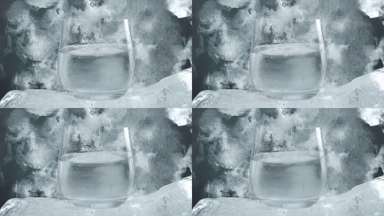 将水滴入冰底的水晶玻璃中。天然矿泉水设计理念。