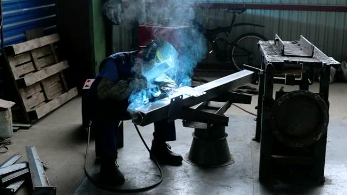 焊工在生产线上焊接金属零件。