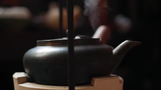 传统的中国金属茶壶在粘土炉上煮沸茶道的水。特写。4k
