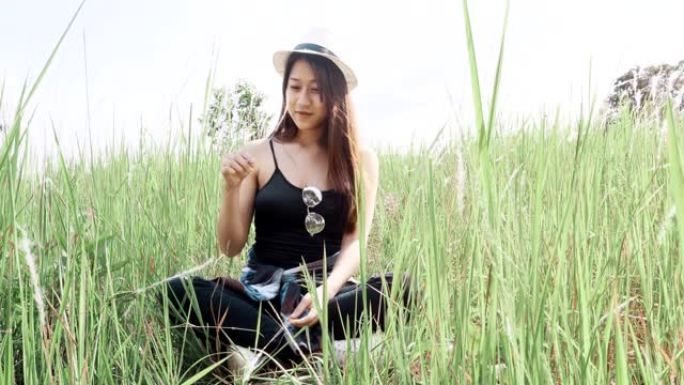 坐在大自然草地上的亚洲妇女