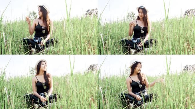 坐在大自然草地上的亚洲妇女