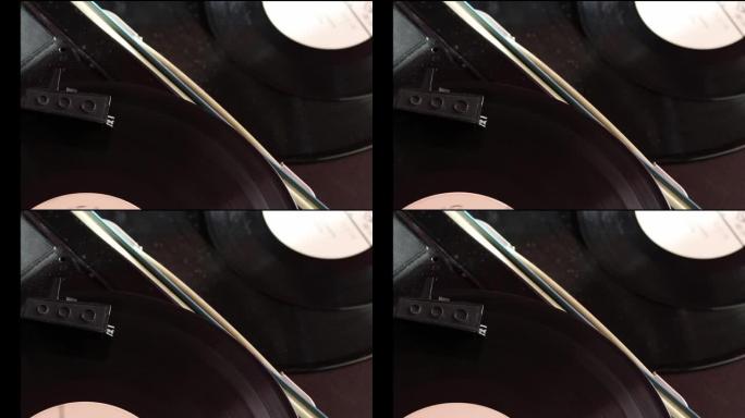 黑胶唱片在播放器上旋转。玩家的头部沿着轨道移动。附近有黑胶唱片。