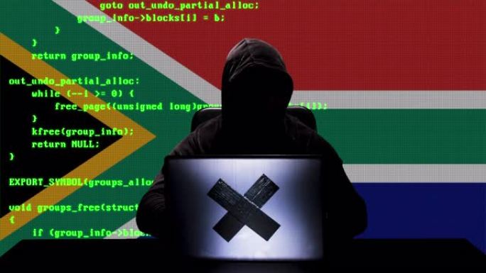 面无表情的南非黑客在他的笔记本电脑上键入代码黑客，背景是南非国旗