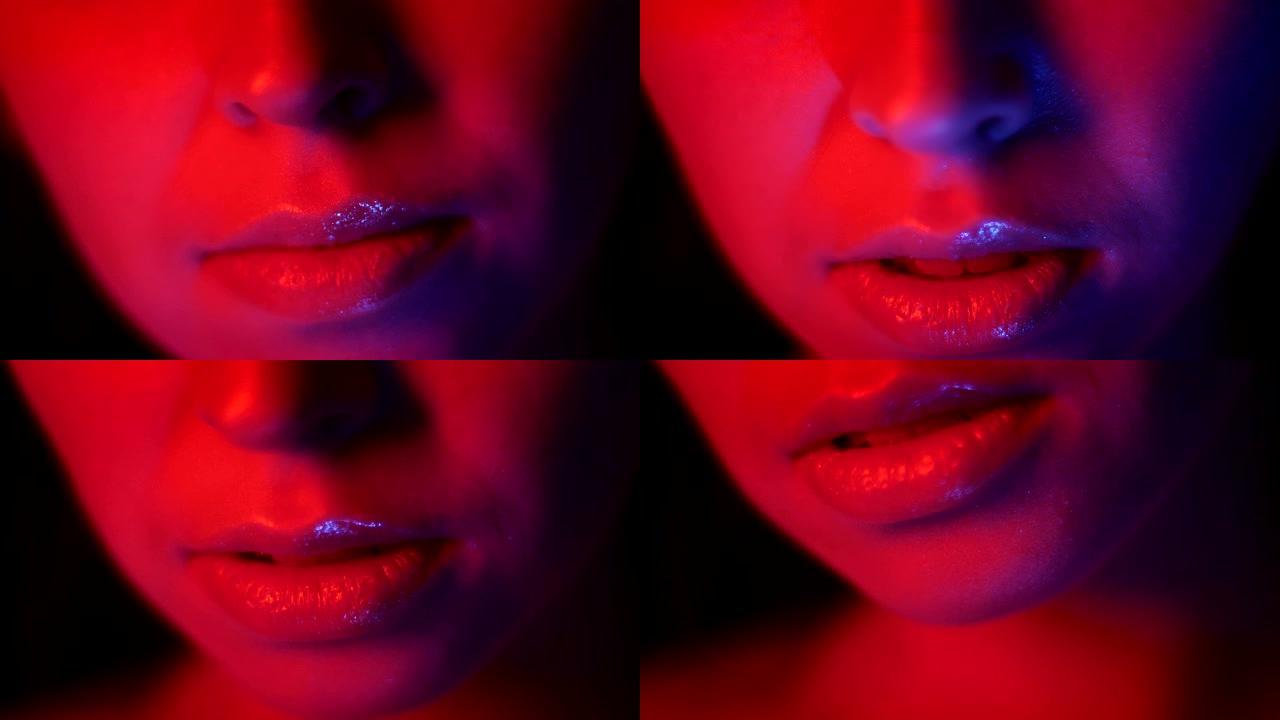 在夜总会拍摄红色霓虹灯和bokeh背景的漂亮女性嘴唇的特写镜头