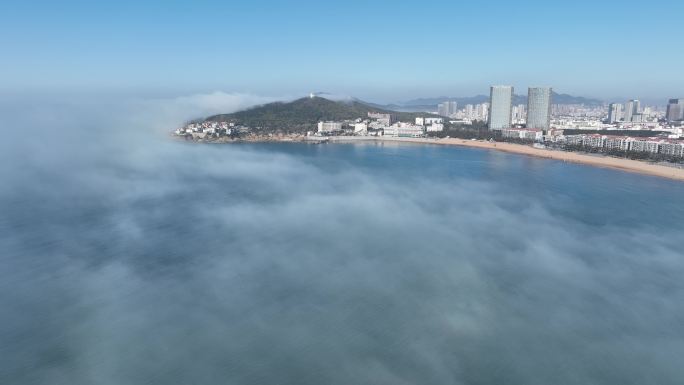 航拍平流雾中的威海国际海水浴场玛珈山