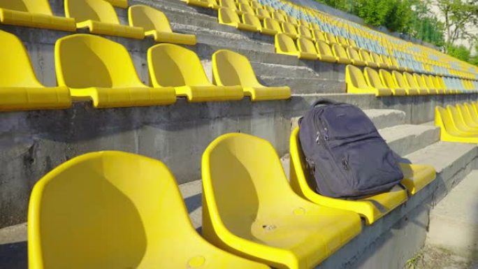 体育场椅子上的背包。学生体育