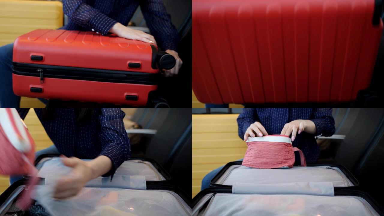 机场的那个女人打开红色的手提箱，拿一个钱包。