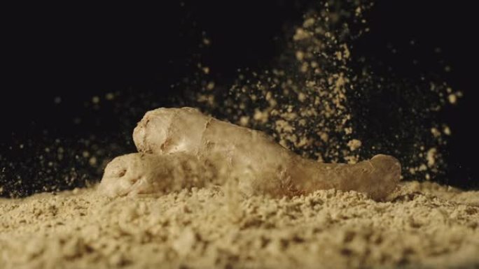 慢动作: 姜根掉落在粉末中，粉末四处散散