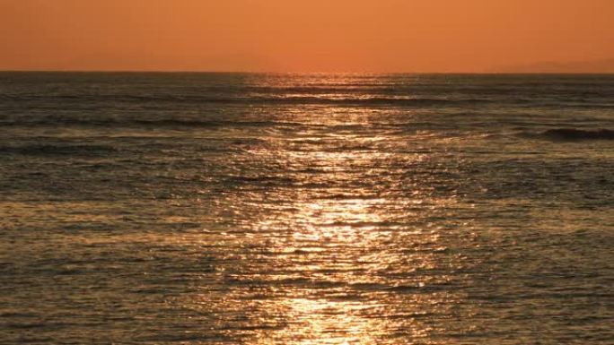 日落反映在海滩上挥舞的海洋上