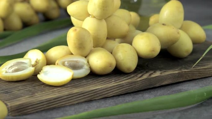 他们把新鲜的枣棕榈放在桌子上用油，保健食品的概念。枣椰树。生枣椰树果实