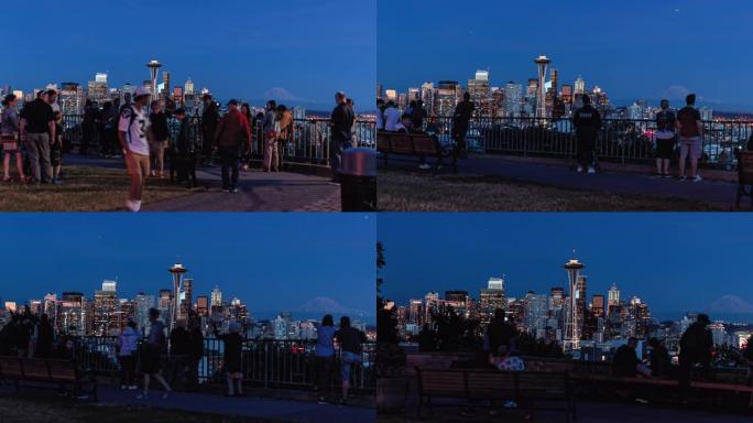 西雅图天际线照明的城市建筑在受欢迎的公园里过度模糊，人群模糊