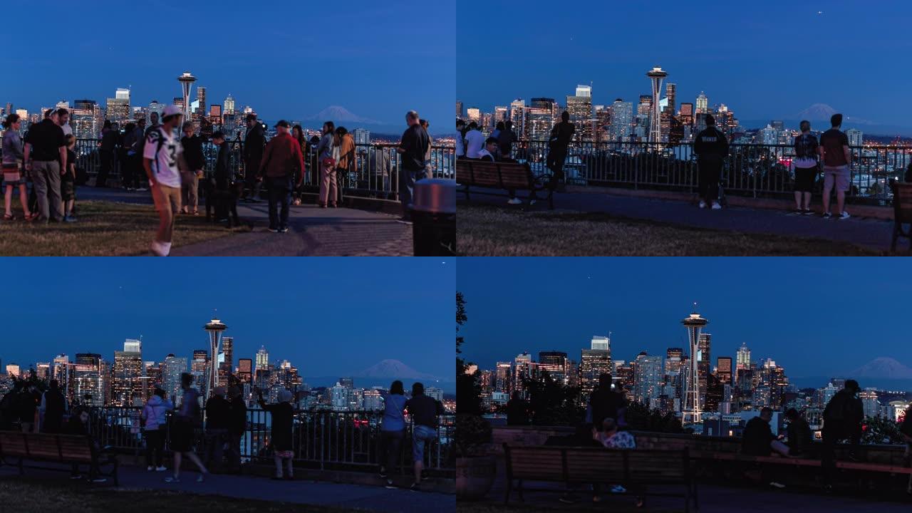 西雅图天际线照明的城市建筑在受欢迎的公园里过度模糊，人群模糊