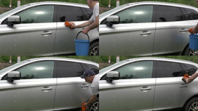 男子双手拿着海绵和水桶，洗车