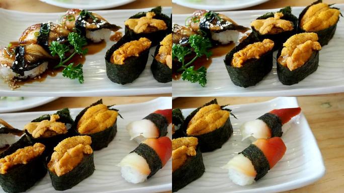 日本料理，寿司套装 (鳗鱼寿司、海胆寿司、鱿鱼寿司) 放在白盘上。平移对。