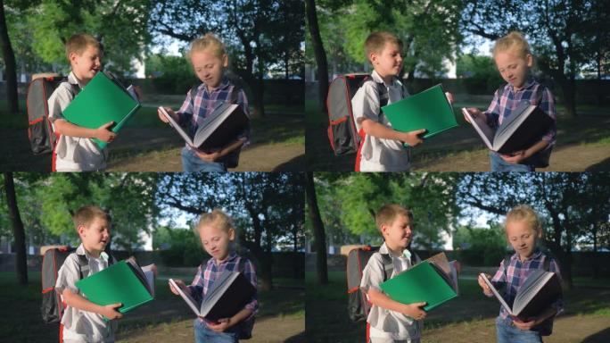 儿童教育，手拿书的学童男孩和女孩在公园里上课后阅读