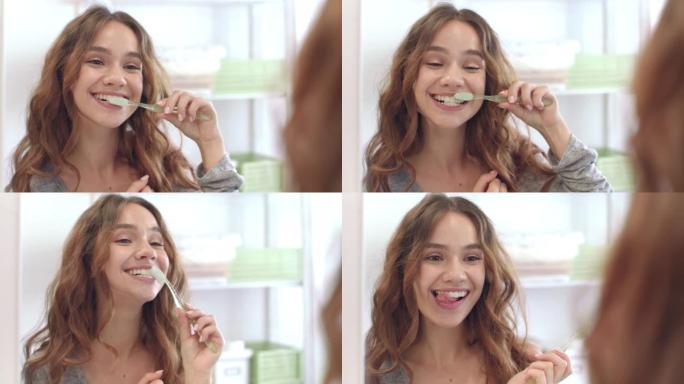 微笑的女人在浴室刷牙前镜子。牙齿和口腔卫生