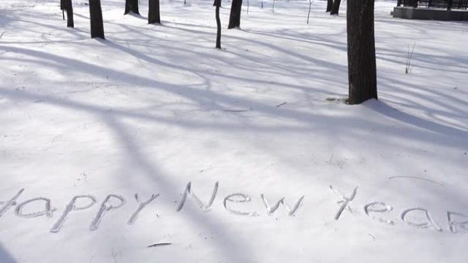 雪地上新年快乐的题词。冬天拍摄。